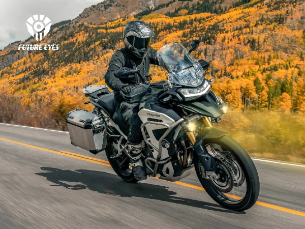 Rider on a Triumph Tiger adventure motorbike with Future Eyes auxiliary lights on, on a mountain road